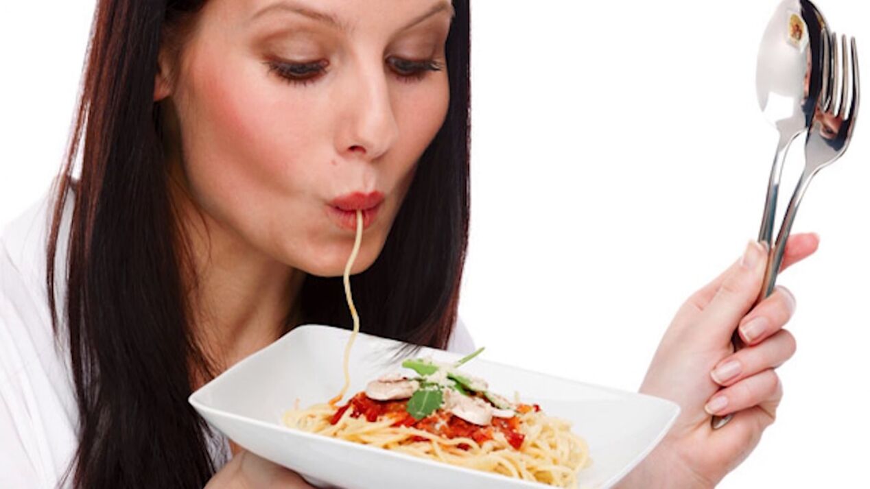 kvinne som spiser spaghetti for å slanke magen